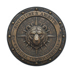 a large, detailed metal compass with a bear's head at the center, surrounded by the words "Adventure Awaits" and "Exploration Wilderness".