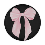 A black tire cover with a large pink bow on it.