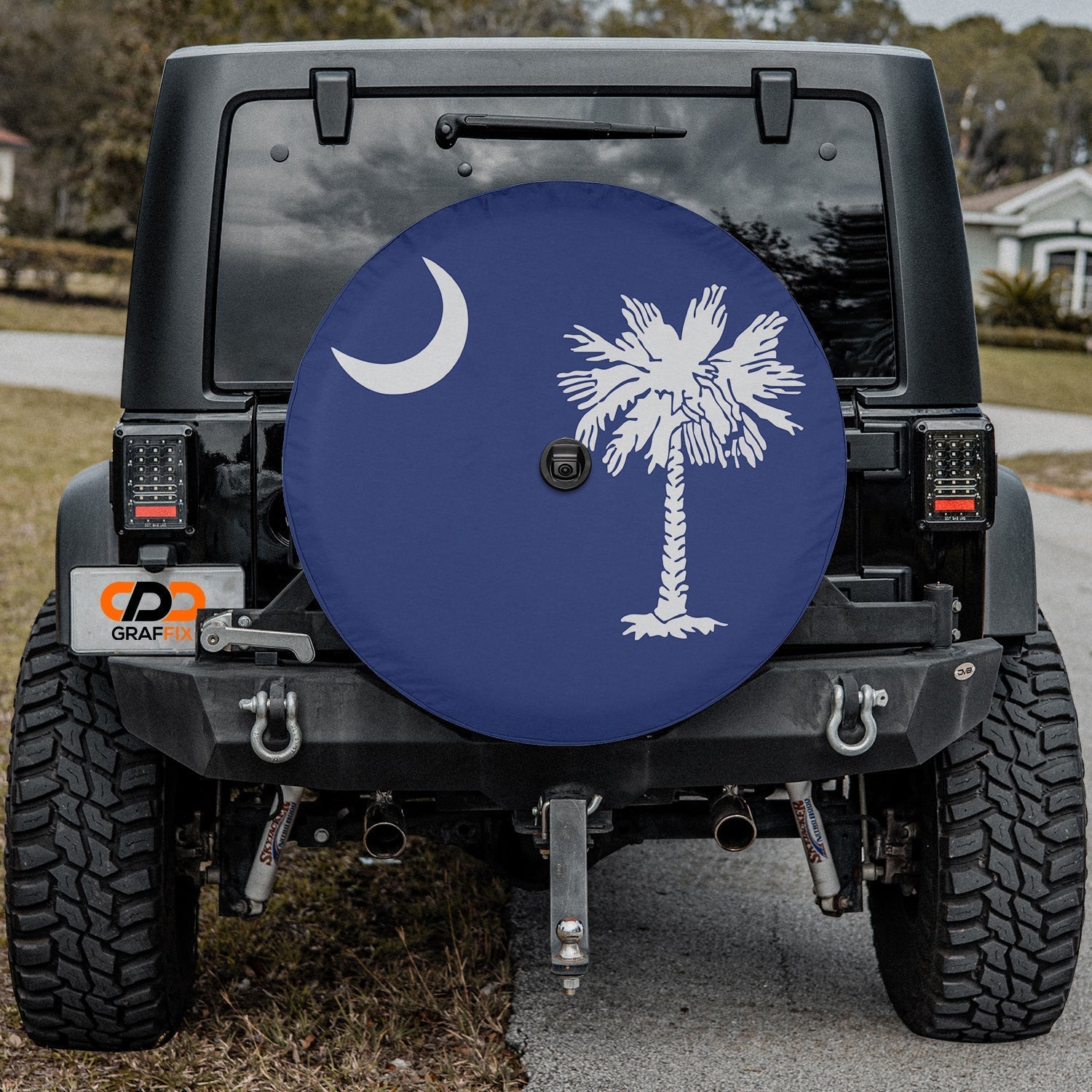 South Carolina palmetto moon spare tire cover fitted on red Jeep Wrangler with desert mountain background