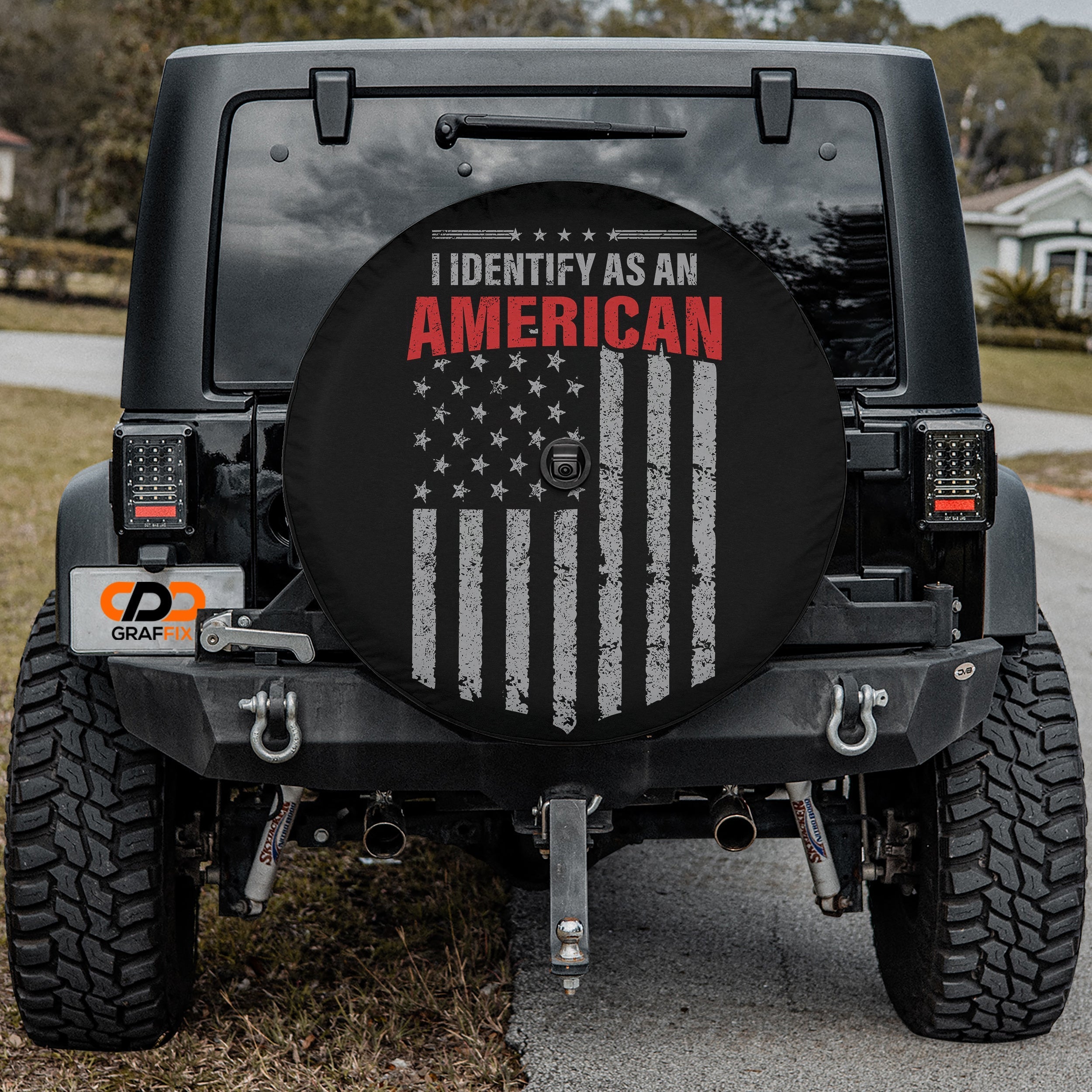 I Identify As American spare tire cover on black Jeep Wrangler showing patriotic flag bold typography
