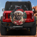 Merry Pug Christmas spare tire cover on a red Jeep Wrangler with Santa pug holding wrapped gifts