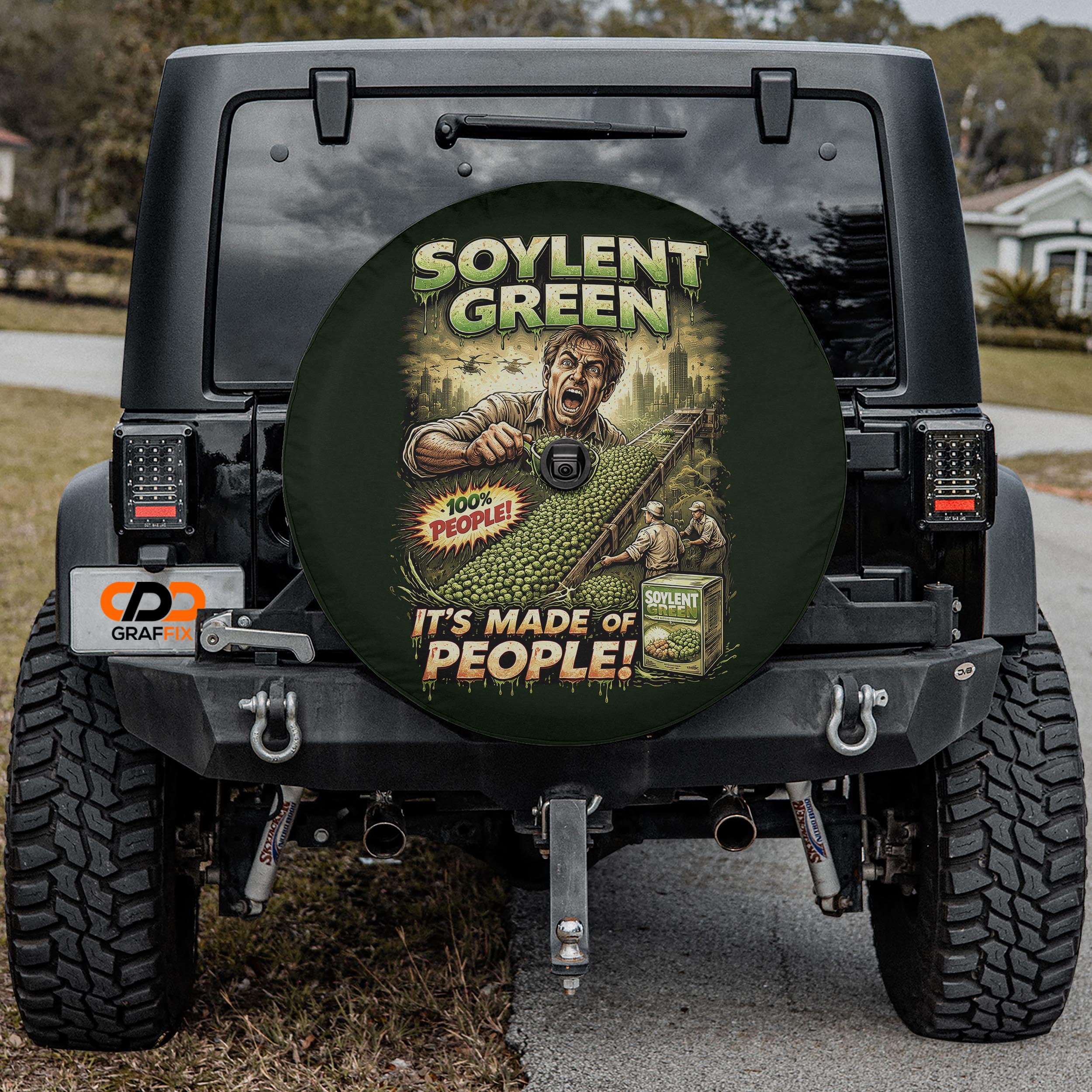 a black Jeep Wrangler with a large tire cover on the rear of the vehicle. The cover has an advertisement for soylent green, which is a product made of people.