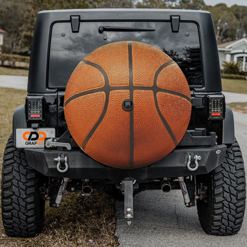 Basketball orange spare tire cover mounted on black Jeep Wrangler rear outdoors view