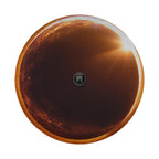 a black camera lens in the center of a circular frame, with a warm, orange-toned background that appears to be the sun or a sunset.