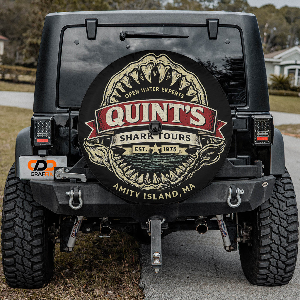 the back of a black Jeep Wrangler with a large shark decal on the rear window.