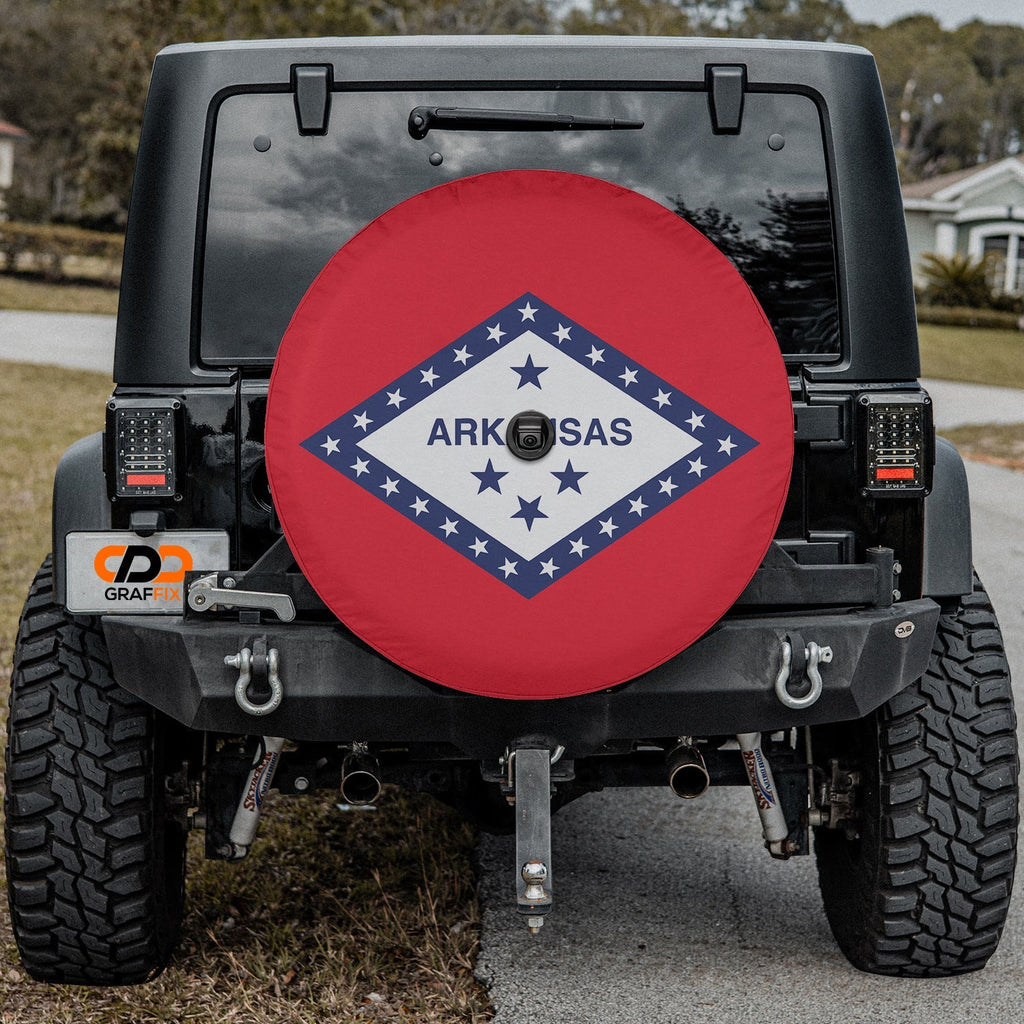 Arkansas state flag spare tire cover on red Jeep Wrangler with desert backdrop showing diamond and star design