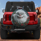 Jolly Holly Yeti spare tire cover on a red Jeep Wrangler with smiling white yeti and red holly