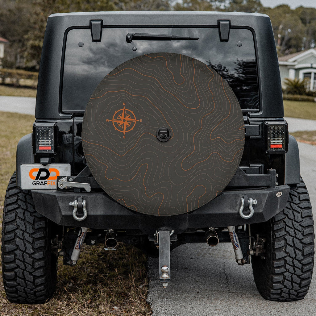 Topographic map tire cover flat round view with orange compass rose and elevation contour lines on dark gray