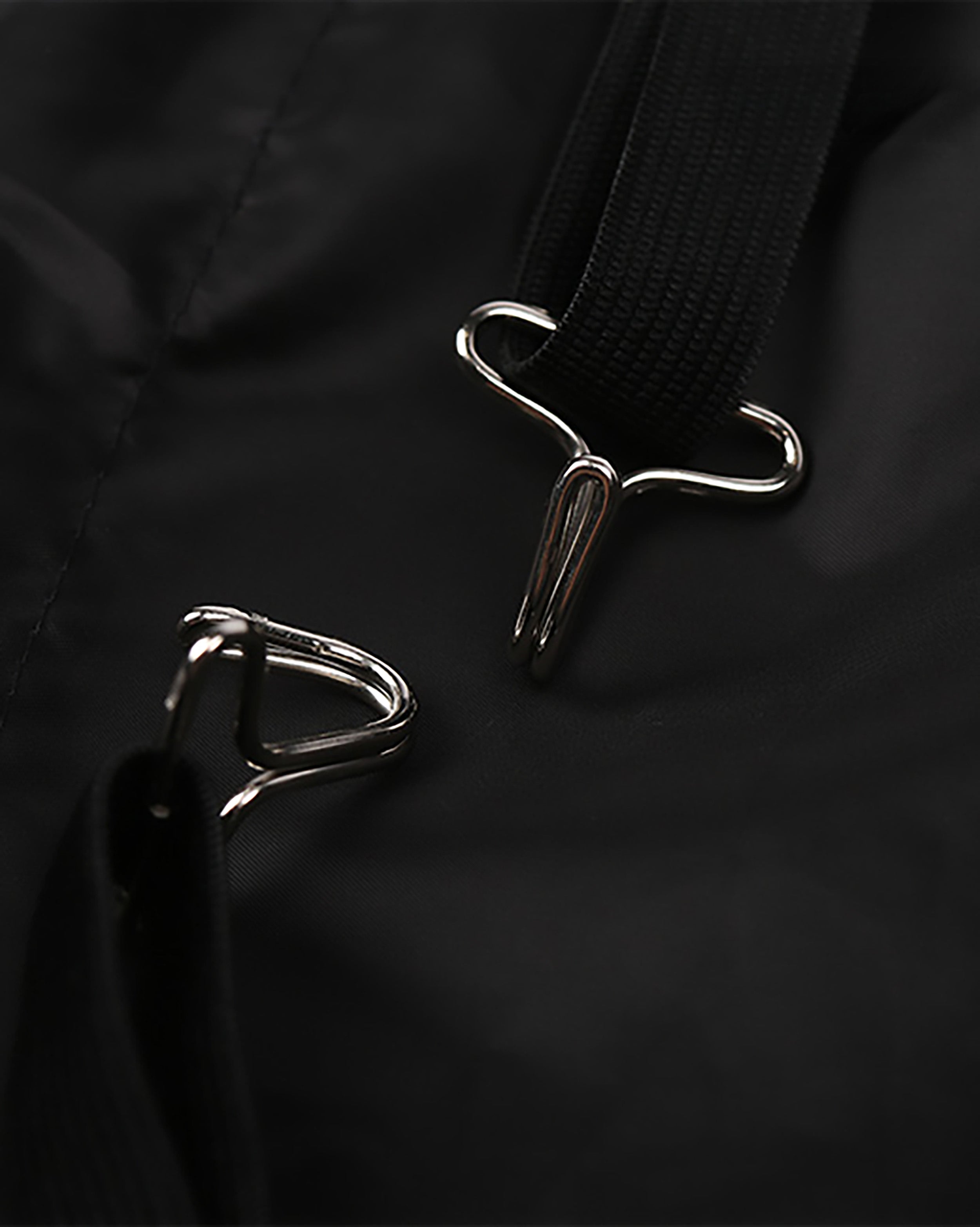 a close-up view of a black strap with a metal hook or buckle attached to it.