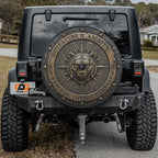 the back of a black Jeep Wrangler with a large, decorative metal shield on the rear window.