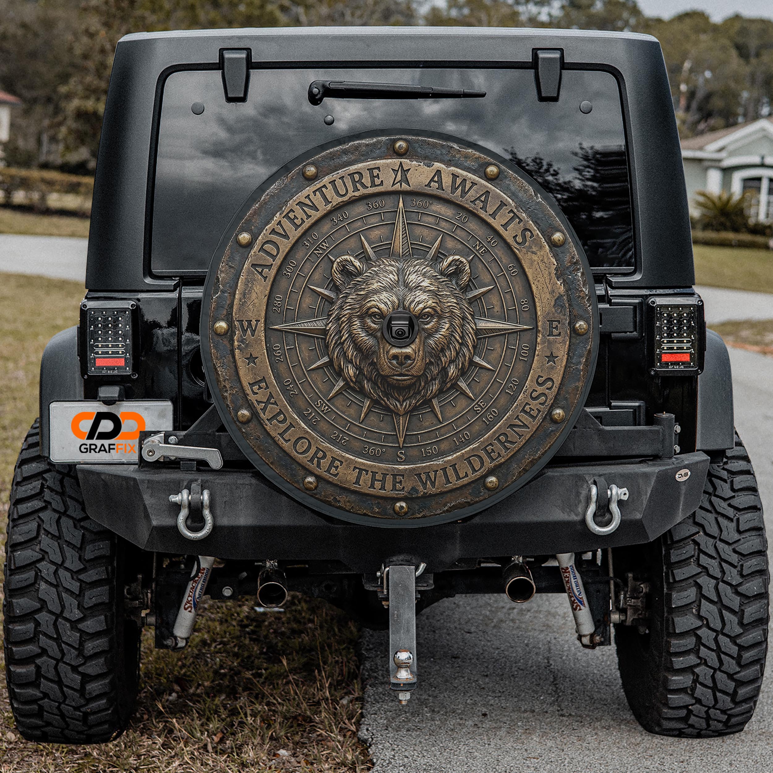 the back of a black Jeep Wrangler with a large, decorative metal shield on the rear window.
