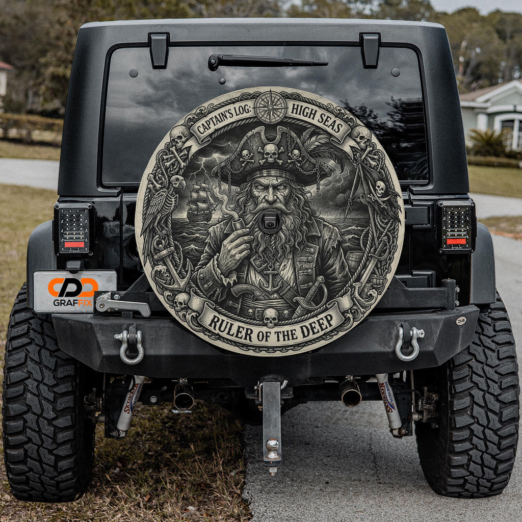 a black Jeep Wrangler with a large, detailed, pirate-themed wheel cover on the rear of the vehicle.