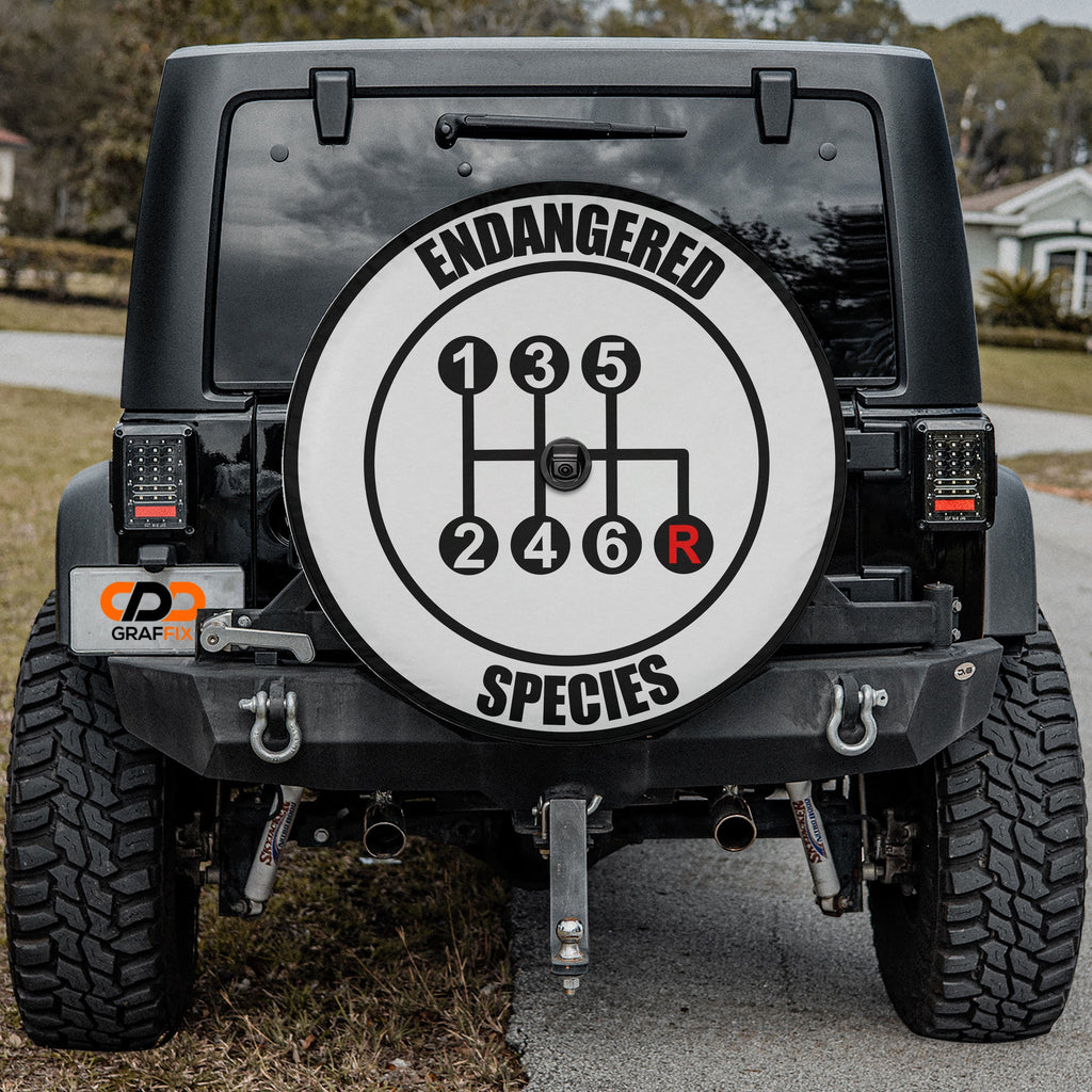 Endangered Species gear shift spare tire cover mounted on Jeep rear with desert backdrop