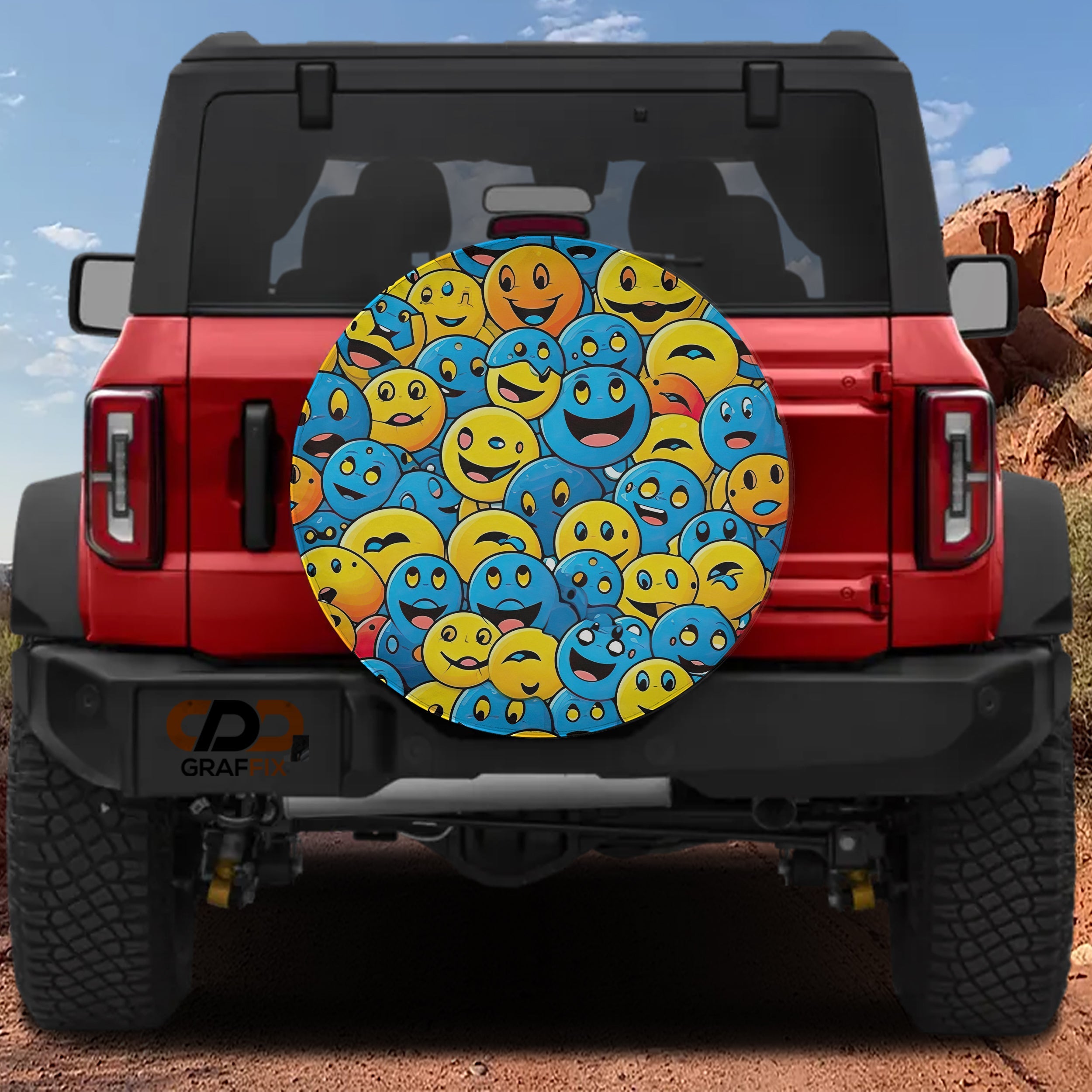 Yellow and blue smiley face cluster tire cover on red Ford Bronco rear gate with red rock canyon view