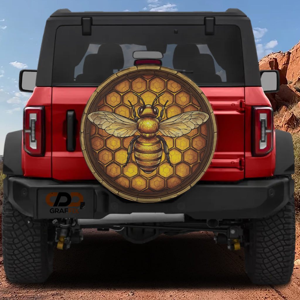 Honeycomb bee spare tire cover mounted on a red Bronco rear with golden hexagon pattern and detailed bee art