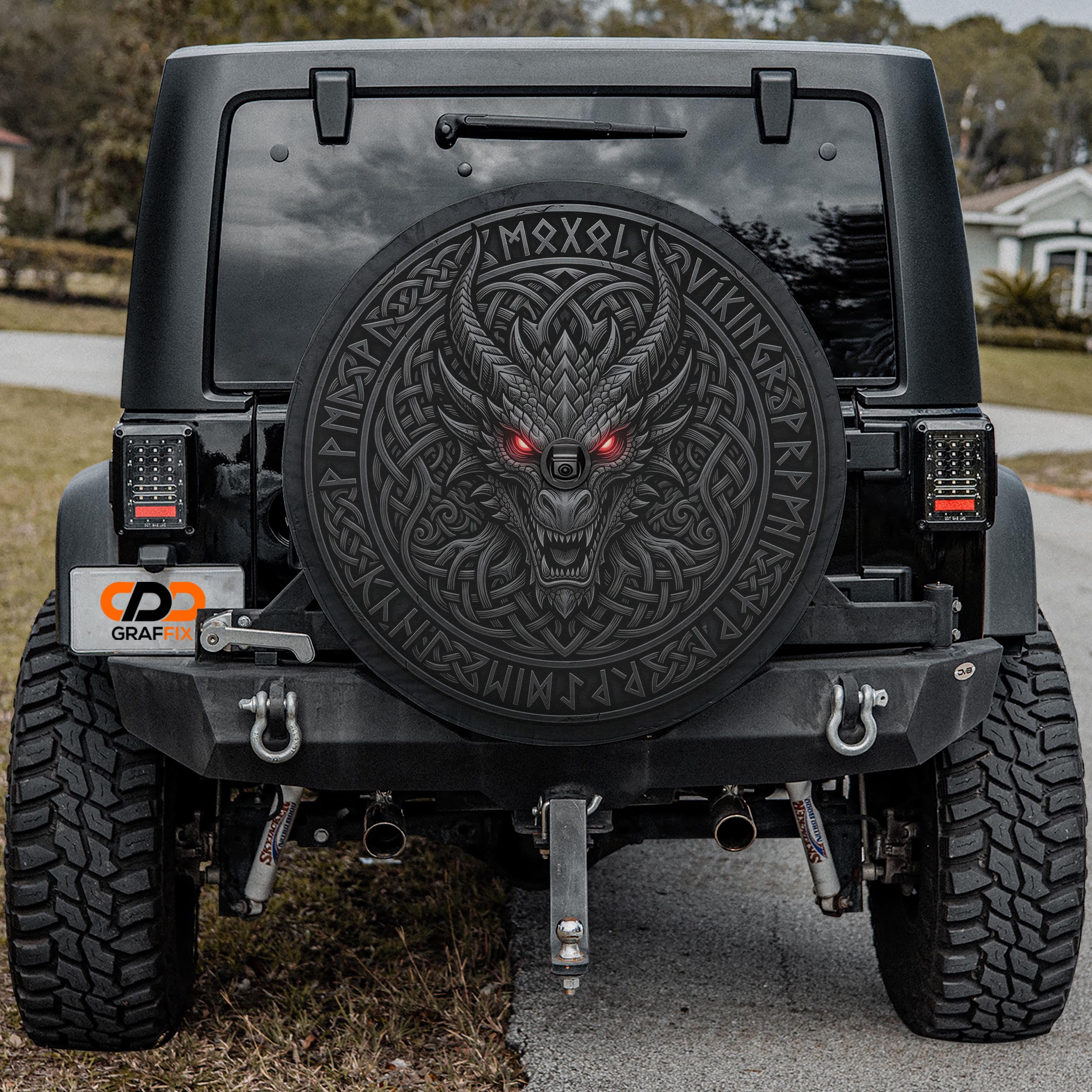 a black Jeep Wrangler with a large, detailed dragon decal on the rear window.