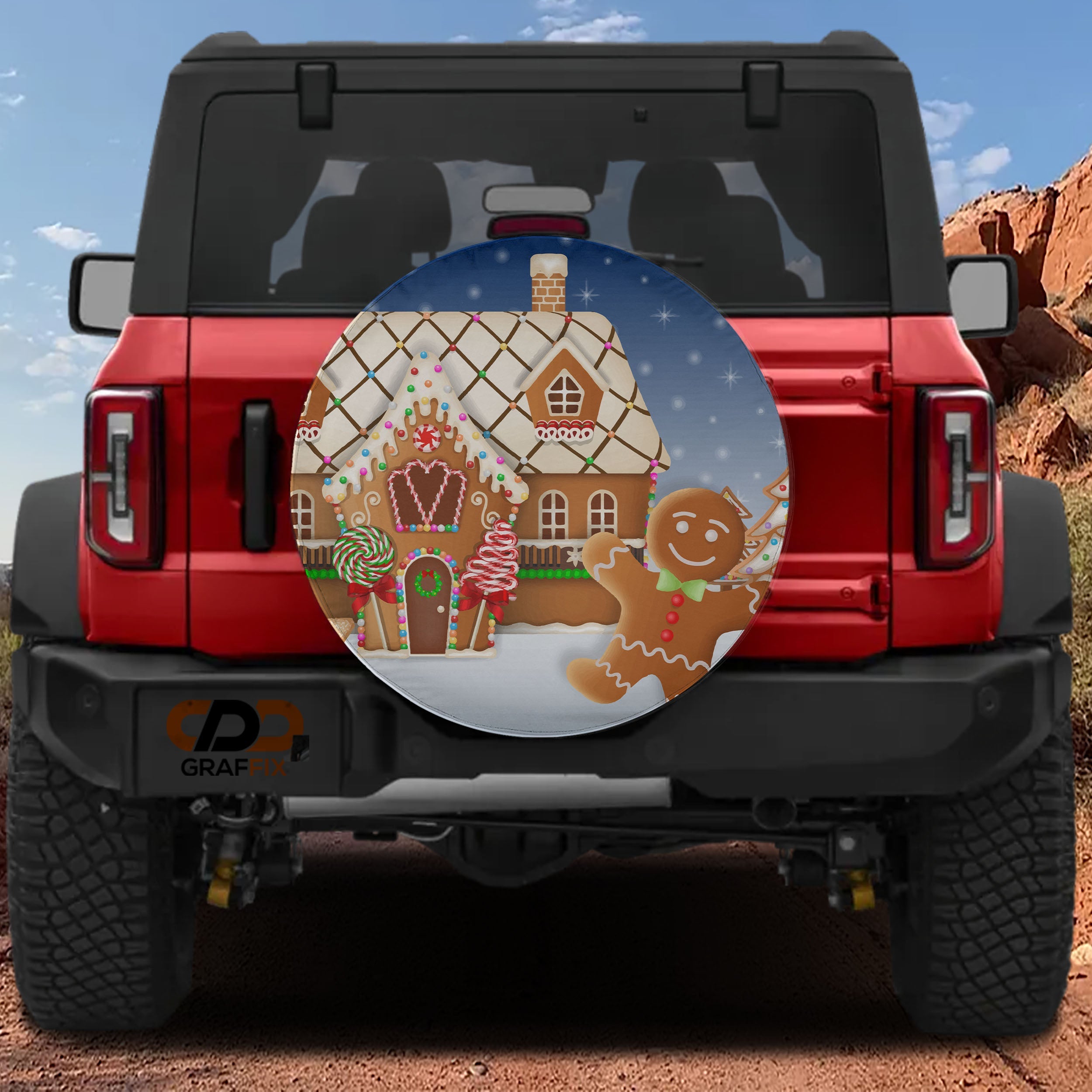 Red Bronco with gingerbread house spare tire cover featuring lollipops candy canes and snowy night sky