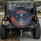 Starport Odyssey UFO spare tire cover installed on black Jeep Wrangler with GRAFFIX plate