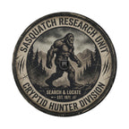 a large, muscular Sasquatch-like creature walking through a forested area with mountains in the background.