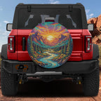 a red Jeep Wrangler with a large, colorful wheel cover depicting a scenic mountain landscape with a winding river.
