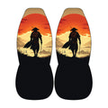 a pair of black seat covers with a design depicting a silhouetted figure of a person walking against a sunset landscape.