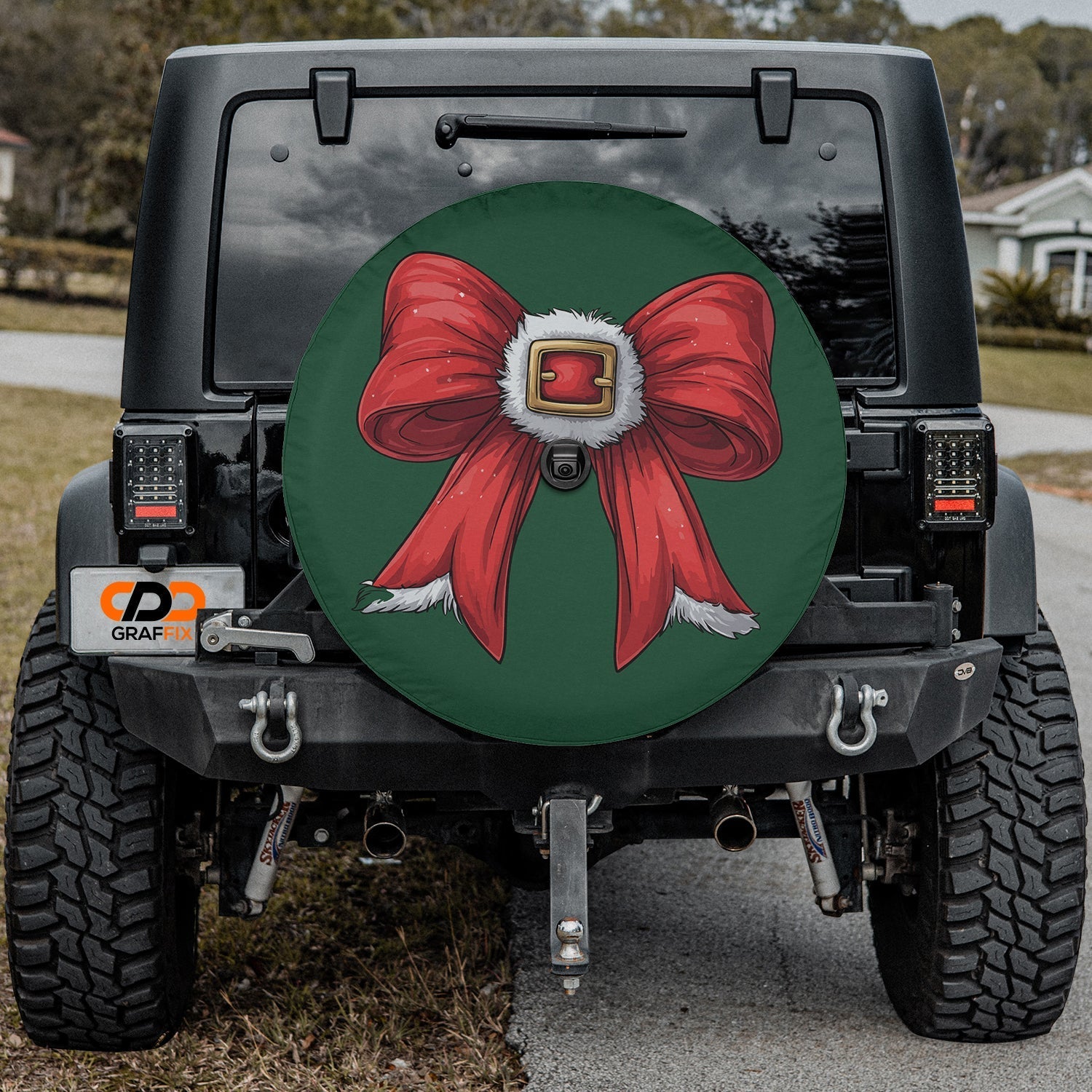 Coquette Santa bow tire cover mounted on black Jeep Wrangler with green ribbon and Santa belt design