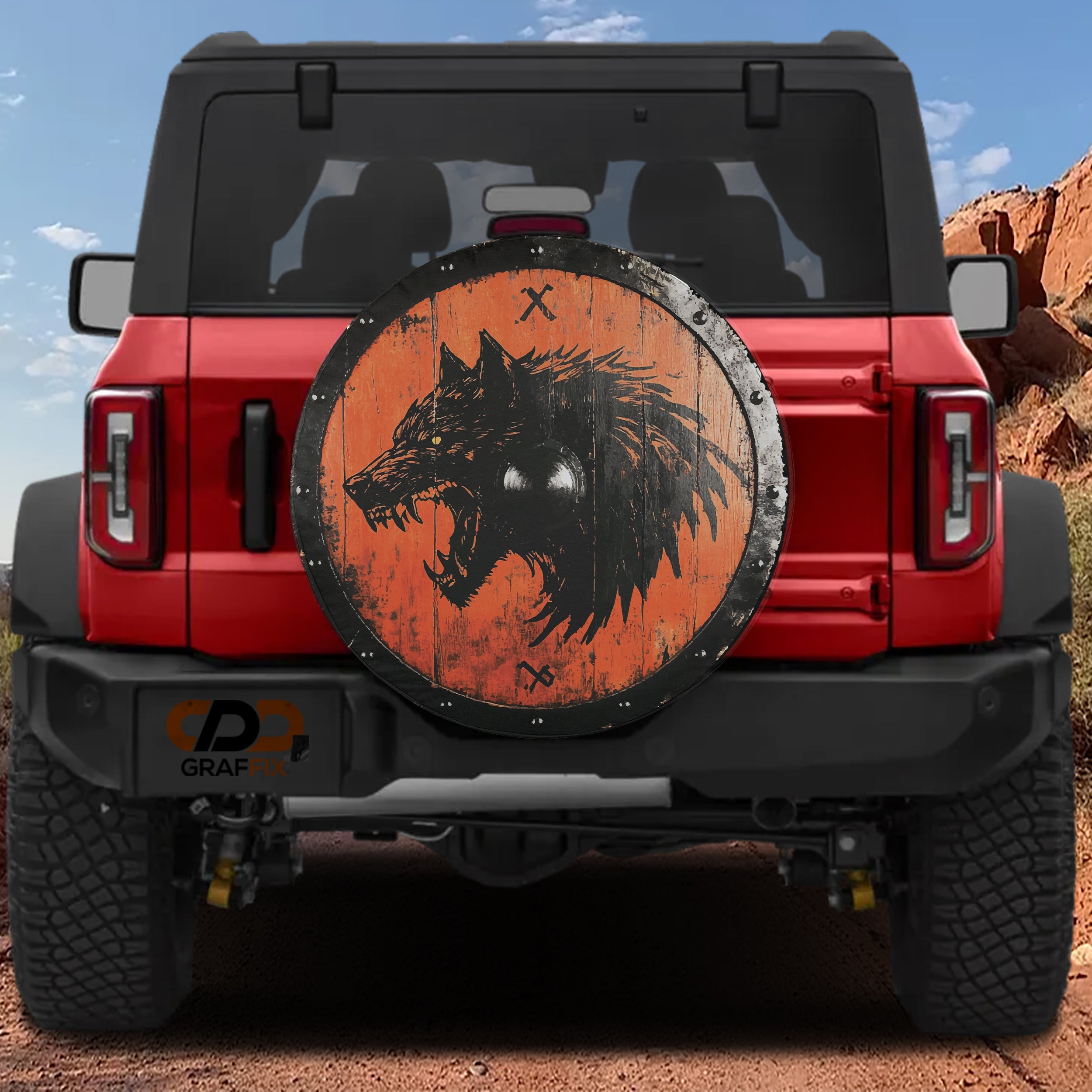 Viking Fenrir wolf shield spare tire cover on red Ford Bronco rustic orange wood and black ironwork