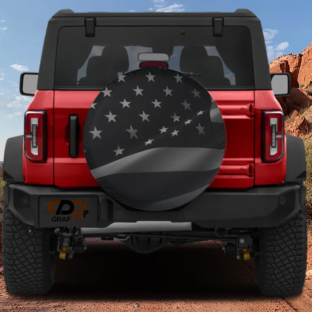 Wavey No Quarter American flag spare tire cover mounted on red Ford Bronco rear with red rock backdrop
