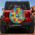 Spectrum of Unity spare tire cover on red Ford Bronco rear with rainbow autism puzzle piece pattern