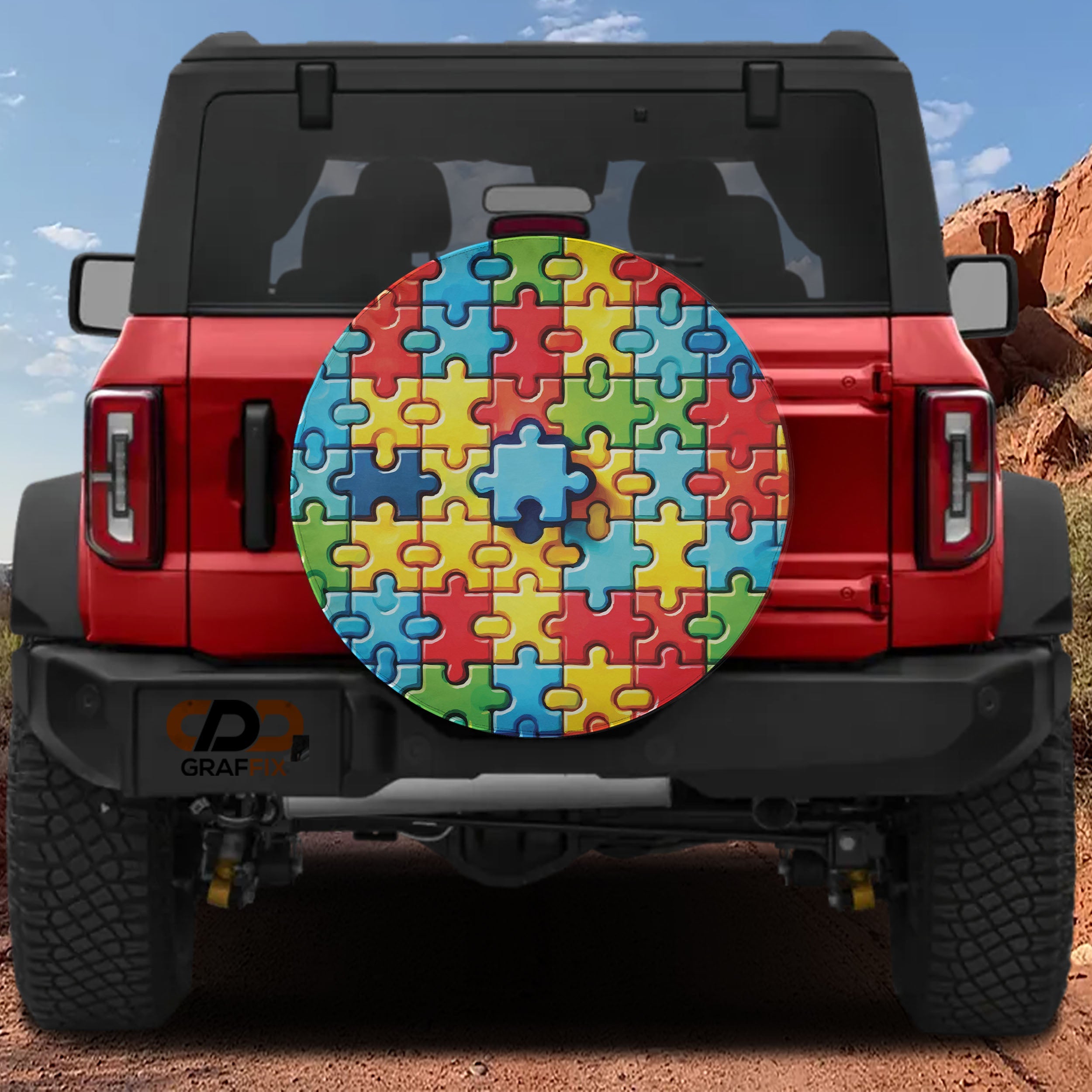 Spectrum of Unity spare tire cover on red Ford Bronco rear with rainbow autism puzzle piece pattern