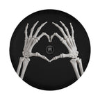 A skeleton hand forming a heart shape on a black background.
