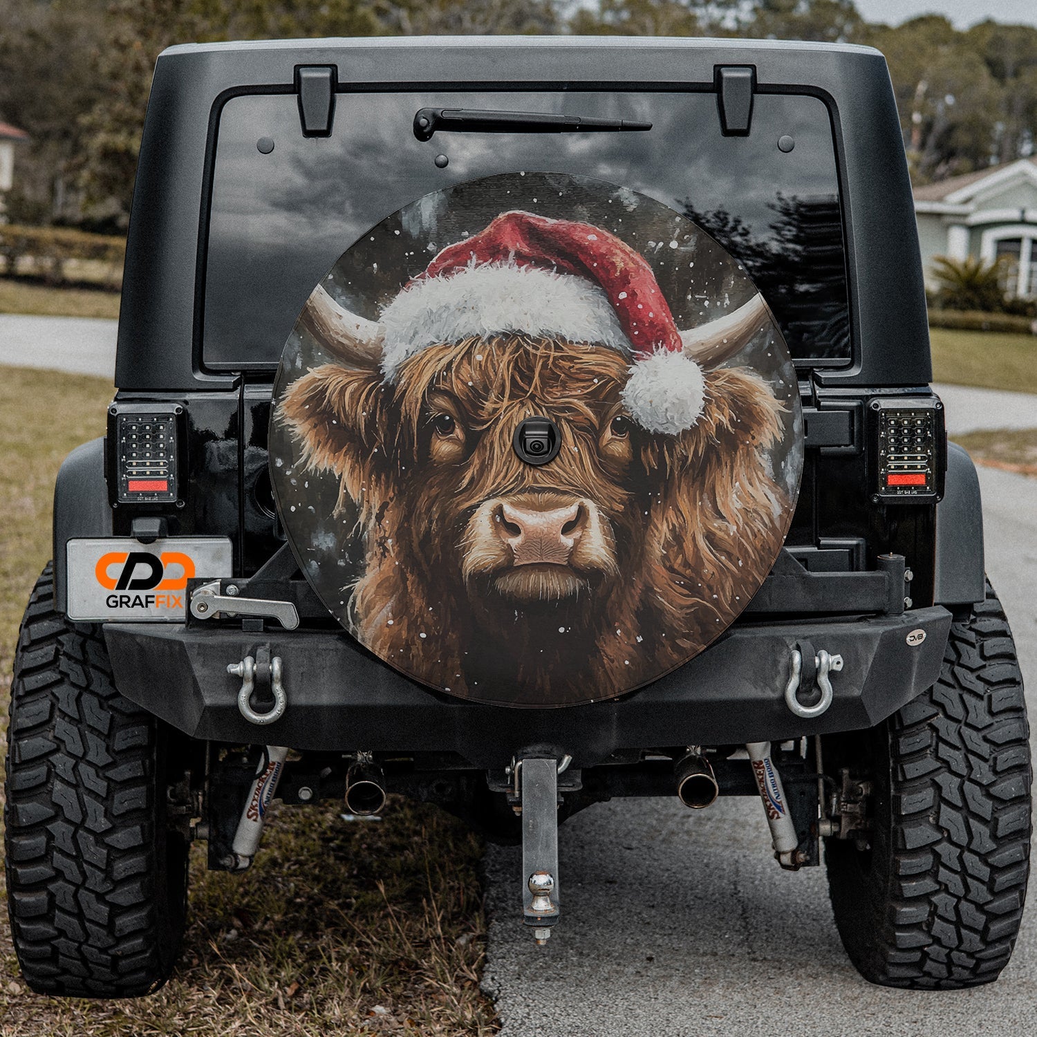 Highland cow with Santa hat spare tire cover displayed on the rear of a Jeep Wrangler tailgate