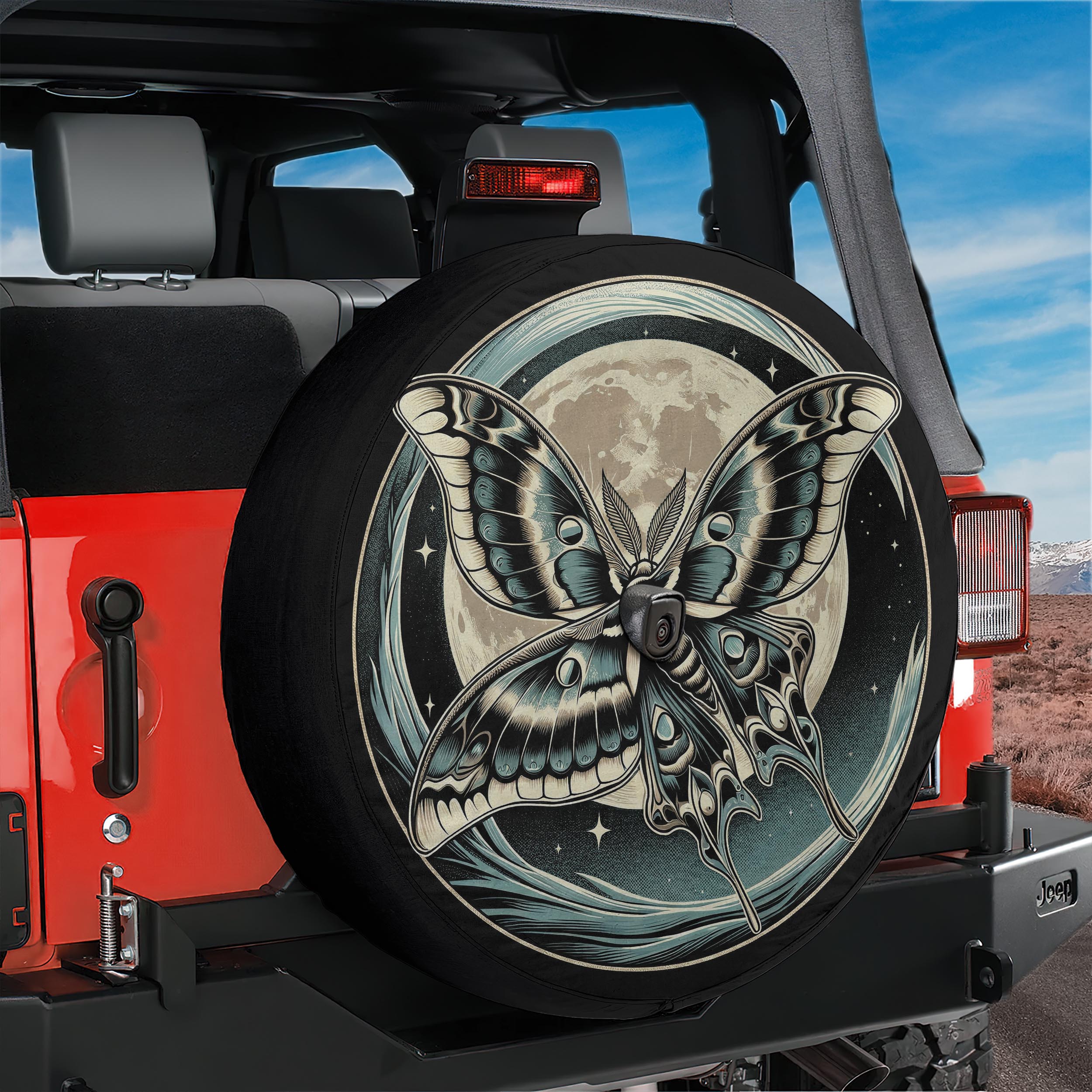 A large, detailed image of a butterfly with a moon and stars design on the tire of a red Jeep.