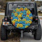 Happy smiley tire cover on black Jeep Wrangler with packed yellow and blue cartoon smiley face pile
