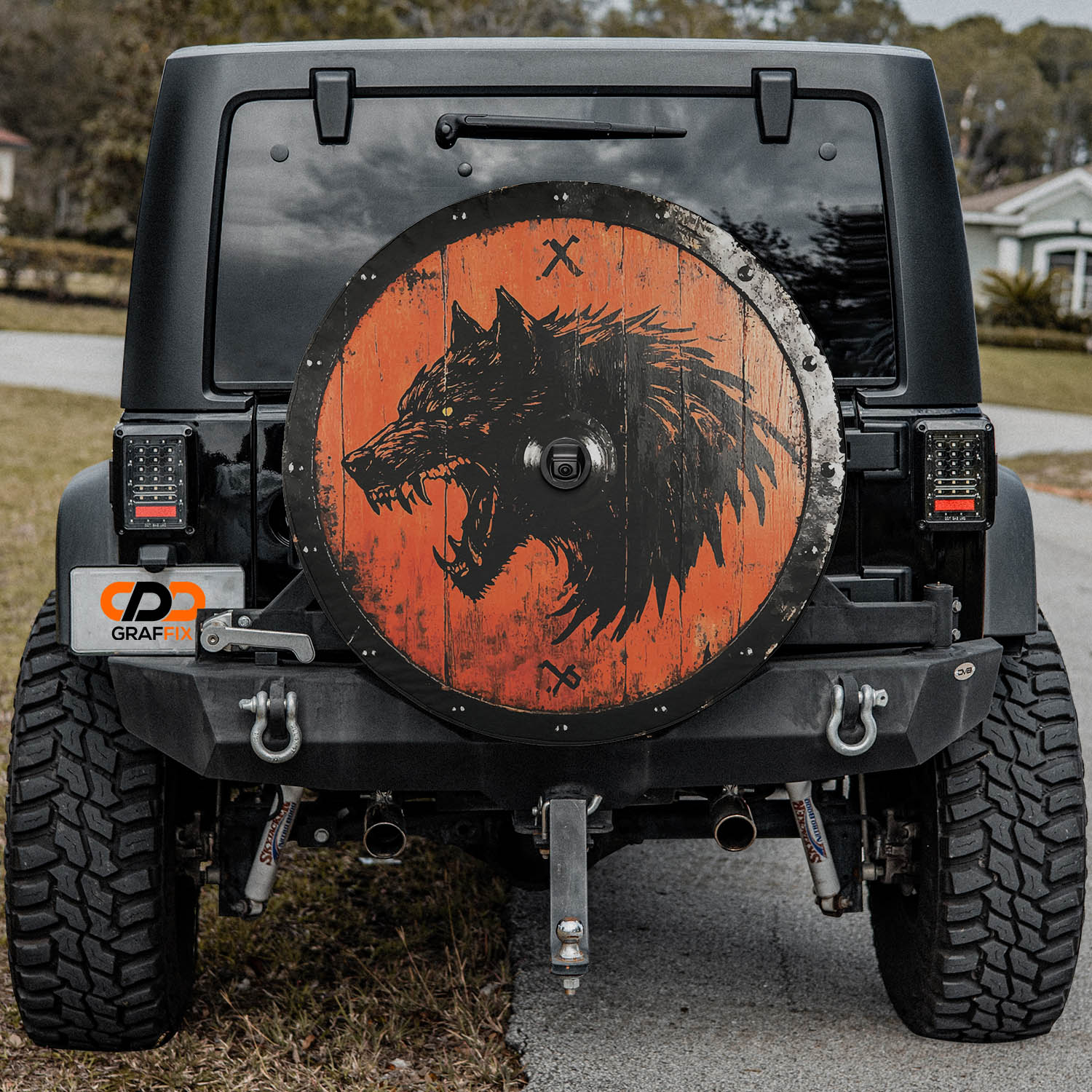 Viking Fenrir shield tire cover mounted on black Jeep Wrangler with orange wood wolf GRAFFIX plate