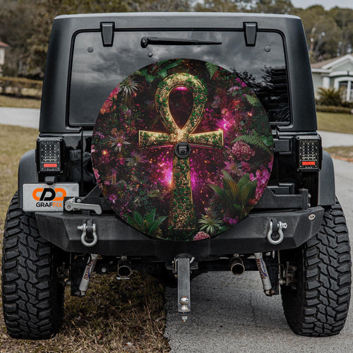 the back of a black Jeep Wrangler with a large, colorful wheel cover featuring an Egyptian hieroglyphic symbol.