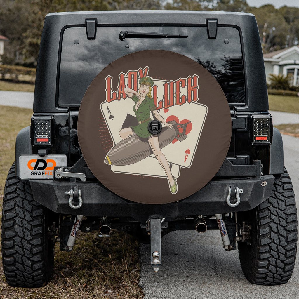 Lady Luck Bombshell spare tire cover with pin-up riding bomb playing cards mounted on Jeep