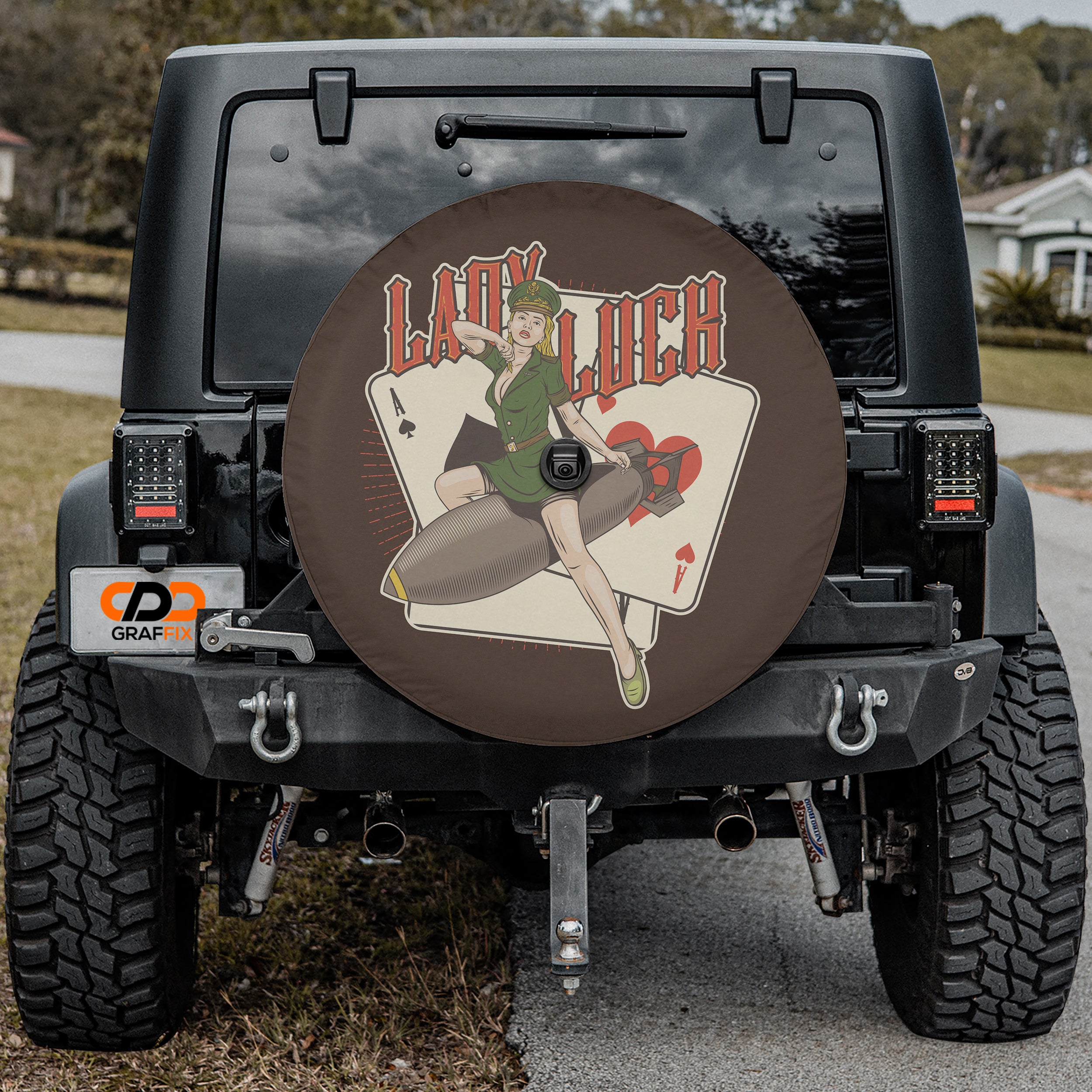 Lady Luck Bombshell spare tire cover with pin-up riding bomb playing cards mounted on Jeep