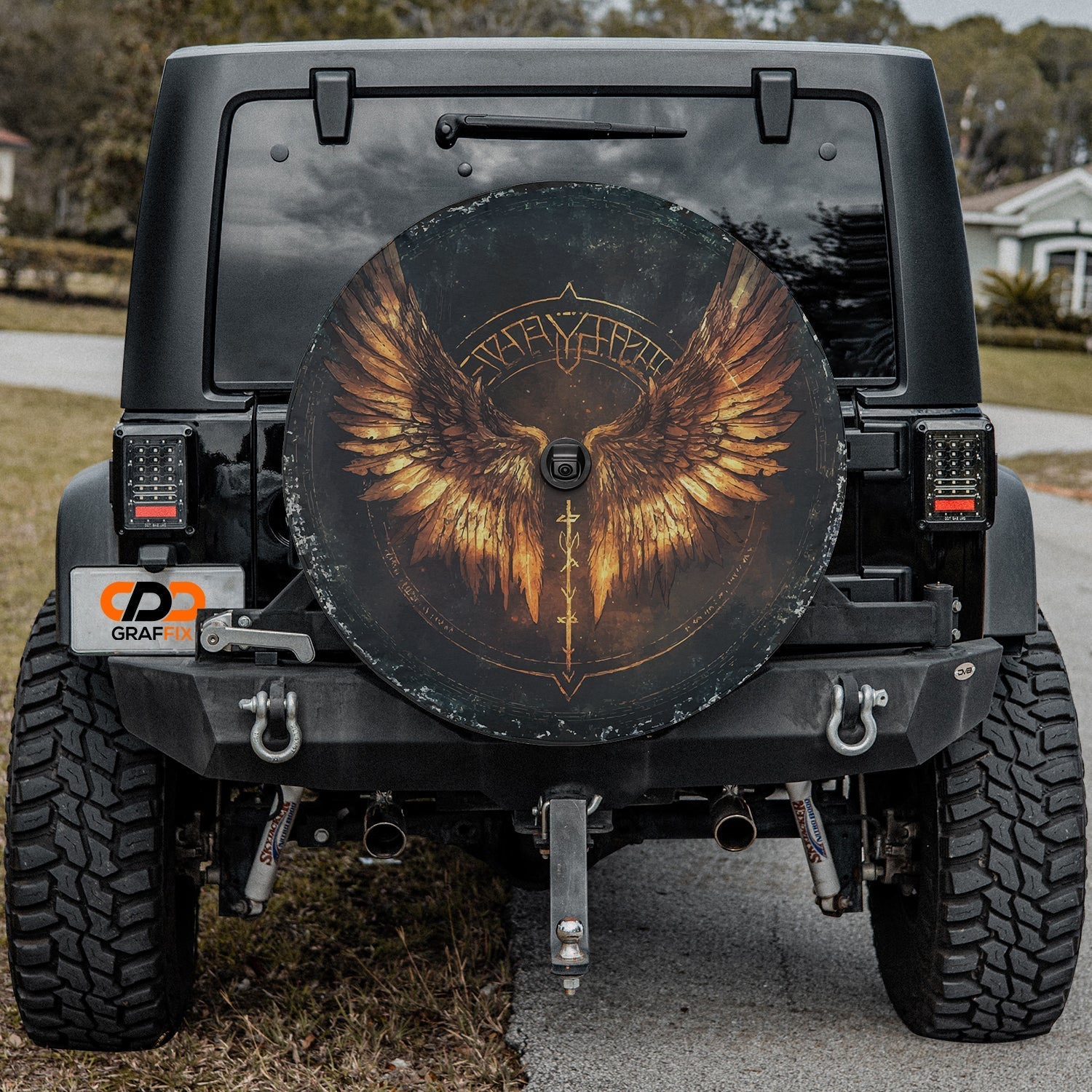 Close-up Norse Valkyrie wings spare tire cover disc showing golden wings, rune sword and backup camera hole
