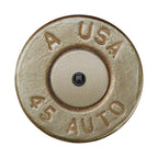 a close-up of a bullet casing with embossed text and a small black object in the center.