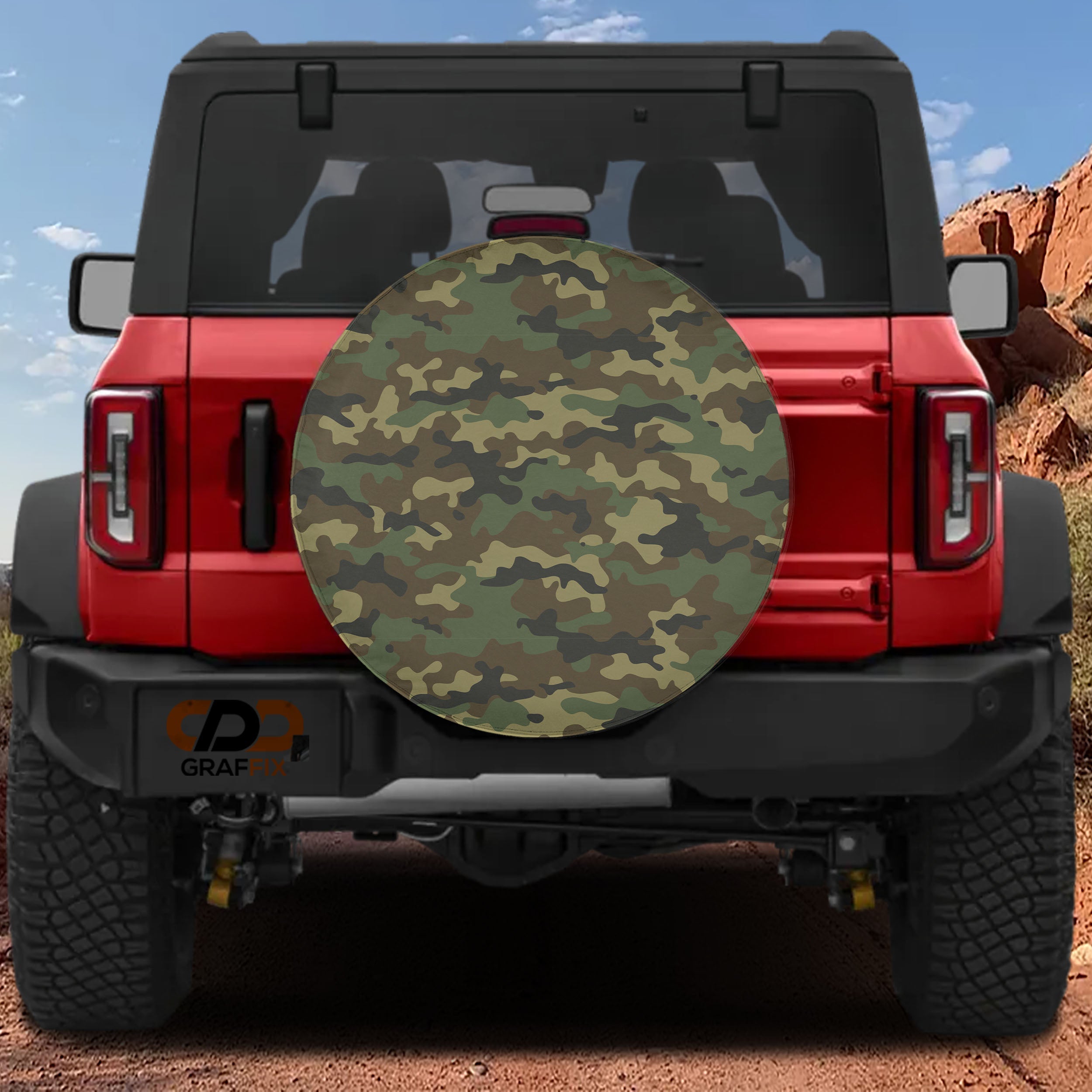 Woodland camouflage spare tire cover on red Ford Bronco with classic green, tan, brown, and black camo print