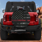 Thin Red Line Subdued American Flag spare tire cover on a red Jeep Wrangler with subdued flag artwork across the cover