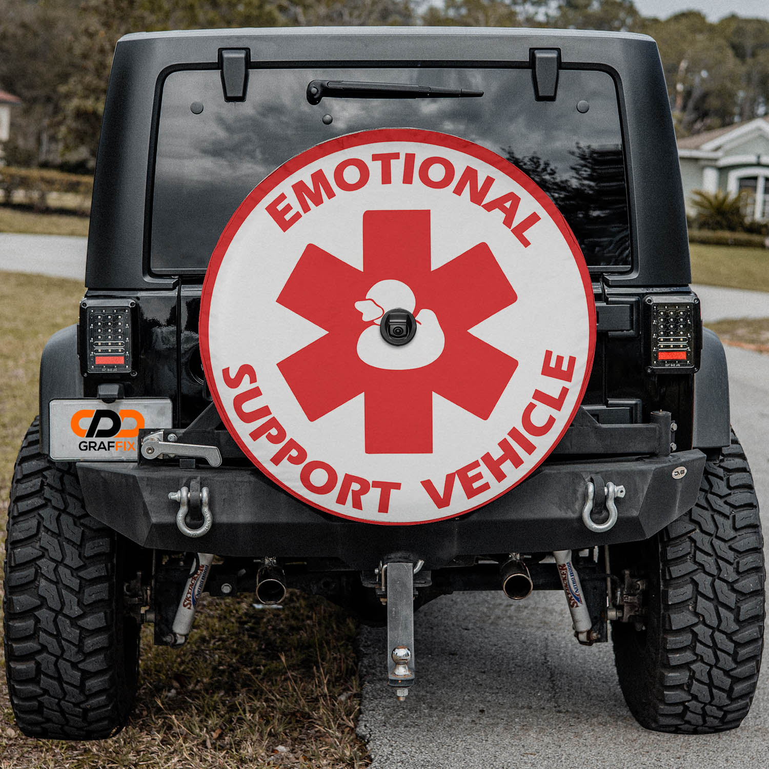 Emotional Support Duck red and white medical cross tire cover on red Ford Bronco rear with rocks