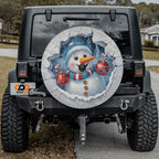Whimsical snowman cracked ice spare tire cover displayed on a Jeep Wrangler tailgate setup