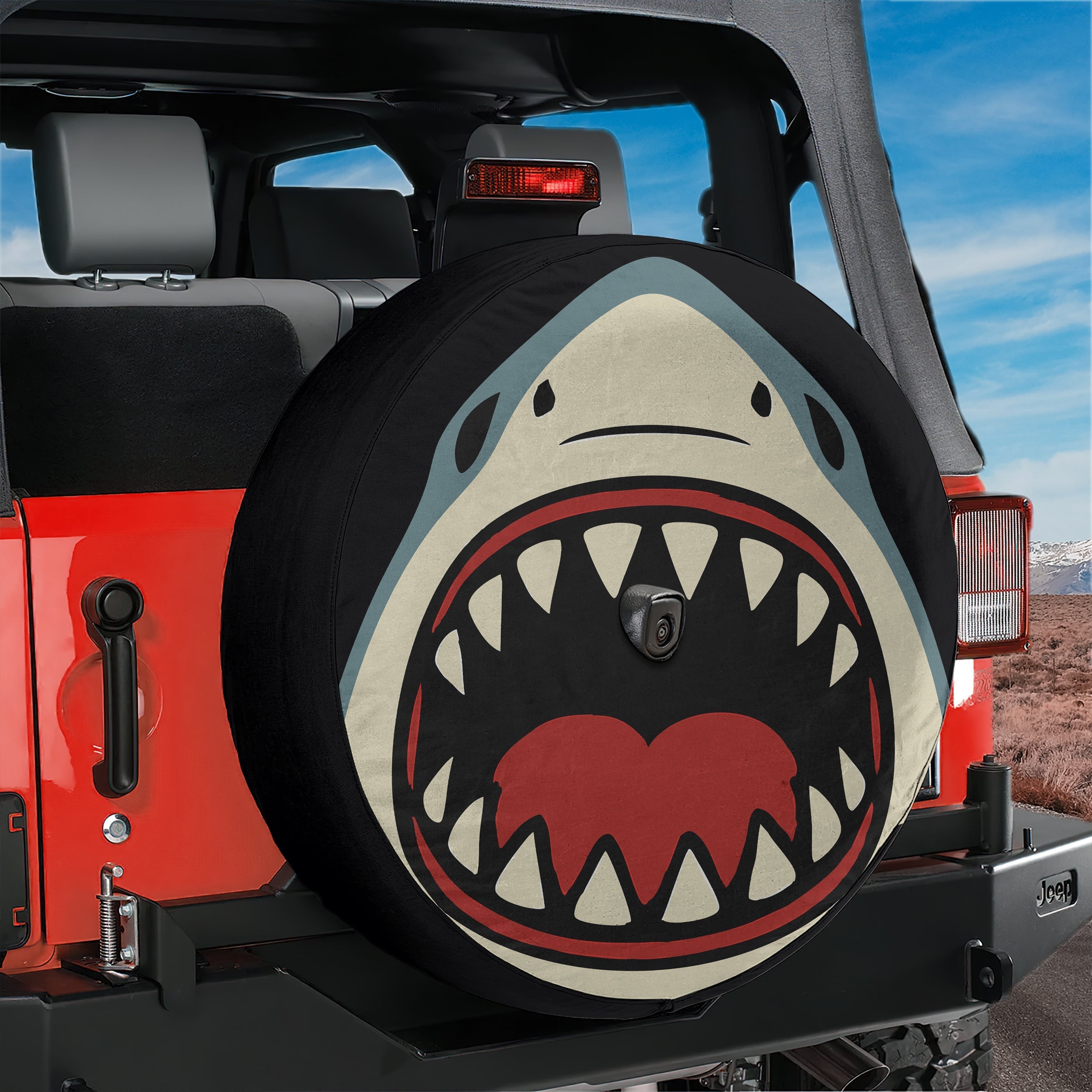 Shark Bite spare tire cover on black Jeep Wrangler with shark face and open jaws print