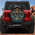 A red Jeep Wrangler with a large anchor-themed spare tire cover on the rear.