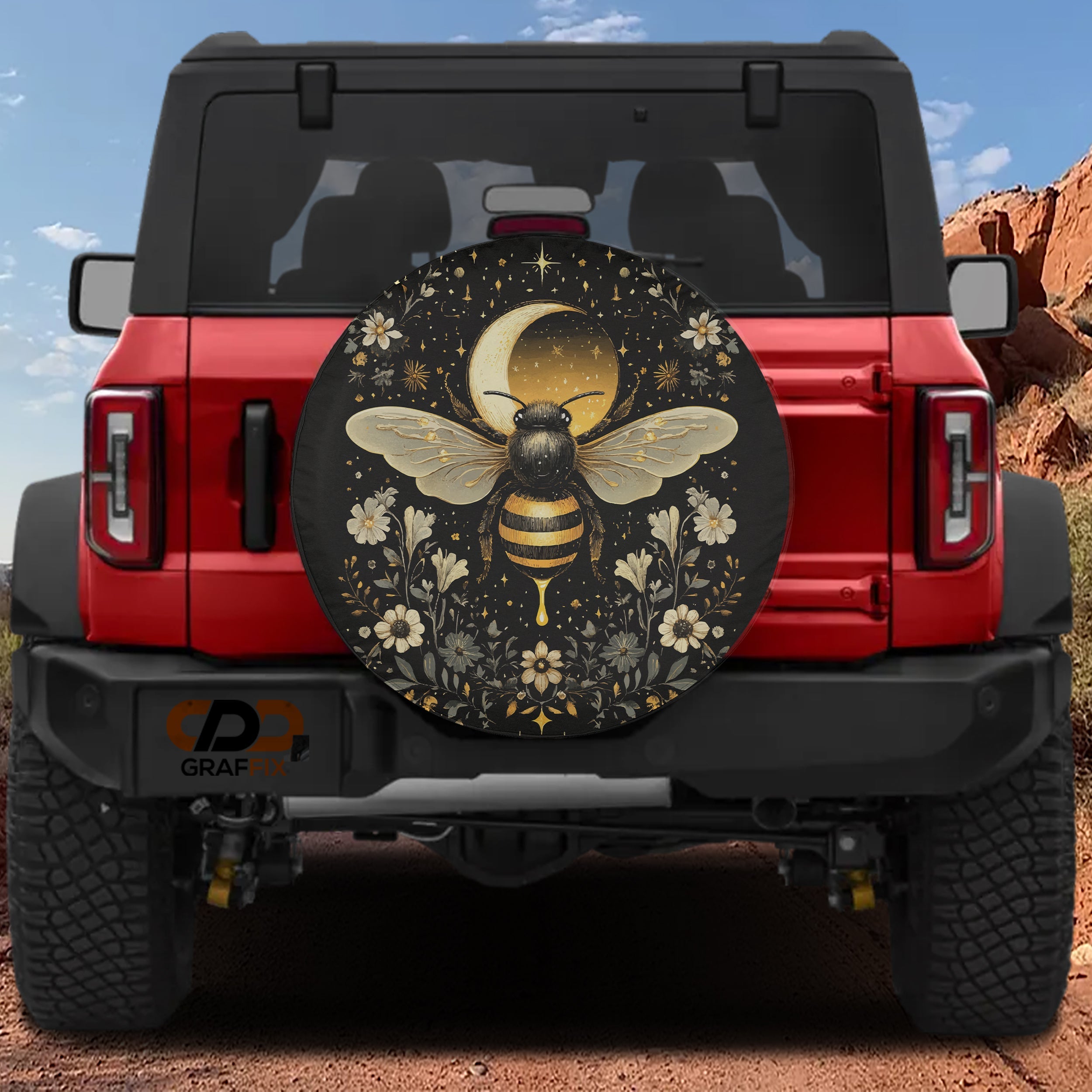 Celestial Buzz bee spare tire cover mounted on a red Bronco rear with golden moon, stars and floral border art