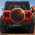 A red Jeep Wrangler with a large orange tire cover on the rear.