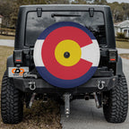 Colorado state flag spare tire cover fitted on black Jeep Wrangler with Graffix plate in driveway setting