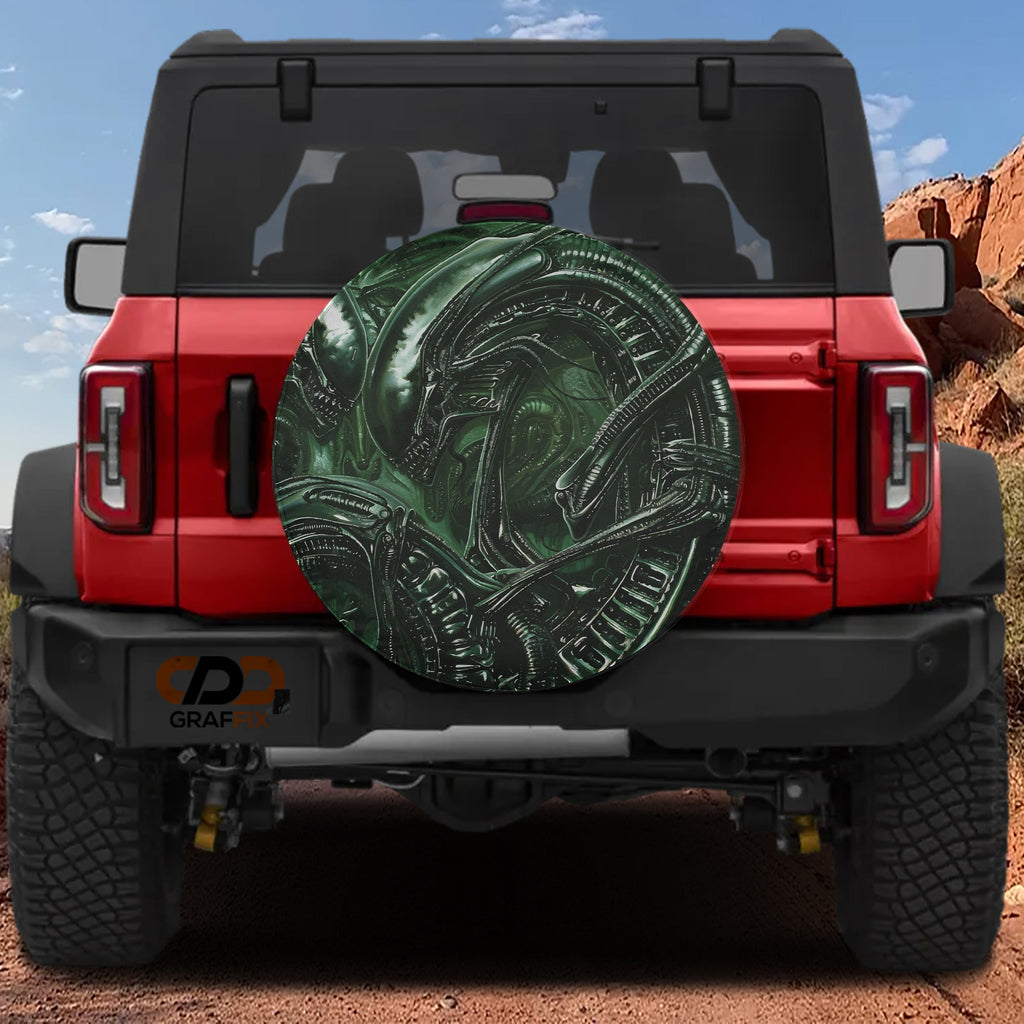 Alien lifeform spare tire cover featuring green H.R. Giger style xenomorph biomechanical artwork detail